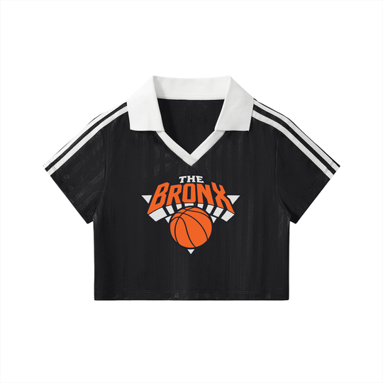 Black cropped polo shirt with 'The Bronx' basketball graphic, white collar, and striped sleeves