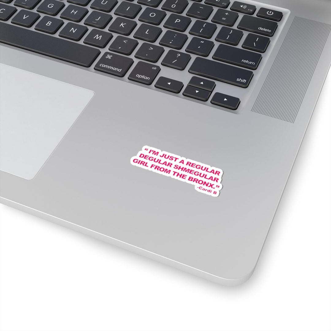 Pink sticker on laptop reading 'I'm just a regular degular shmegular girl from the Bronx' - Cardi B