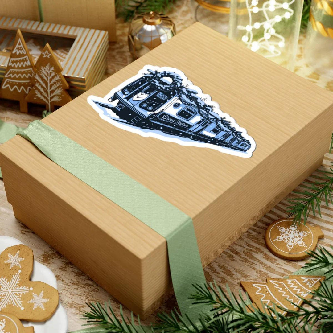Bronx Native train sticker on gift box with holiday decor, gingerbread cookies, and green ribbon
