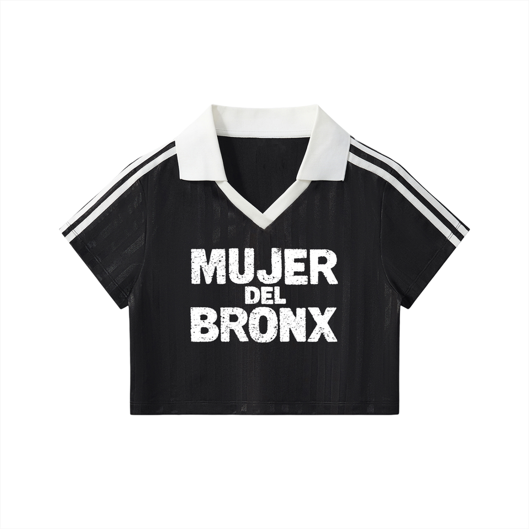 Black crop top with white collar and side stripes, featuring 'MUJER DEL BRONX' text on a white background.
