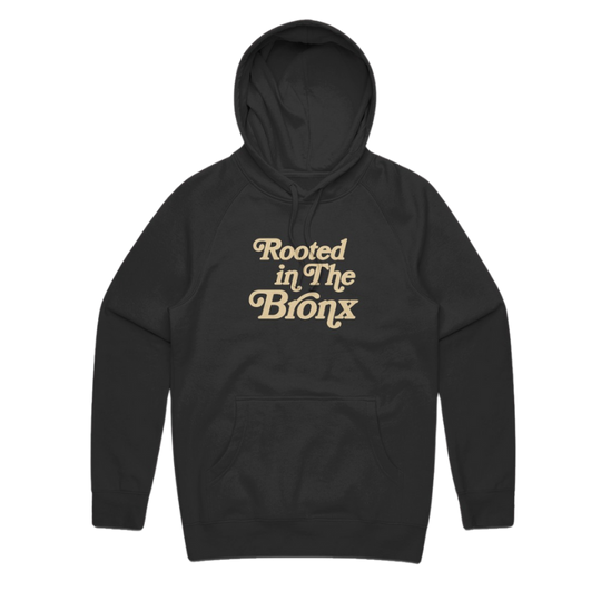Black hoodie with beige text saying Rooted in The Bronx, front pocket and drawstring hood