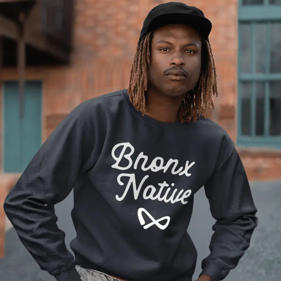 Person wearing a black sweatshirt with 'Bronx Native' text in an urban setting
