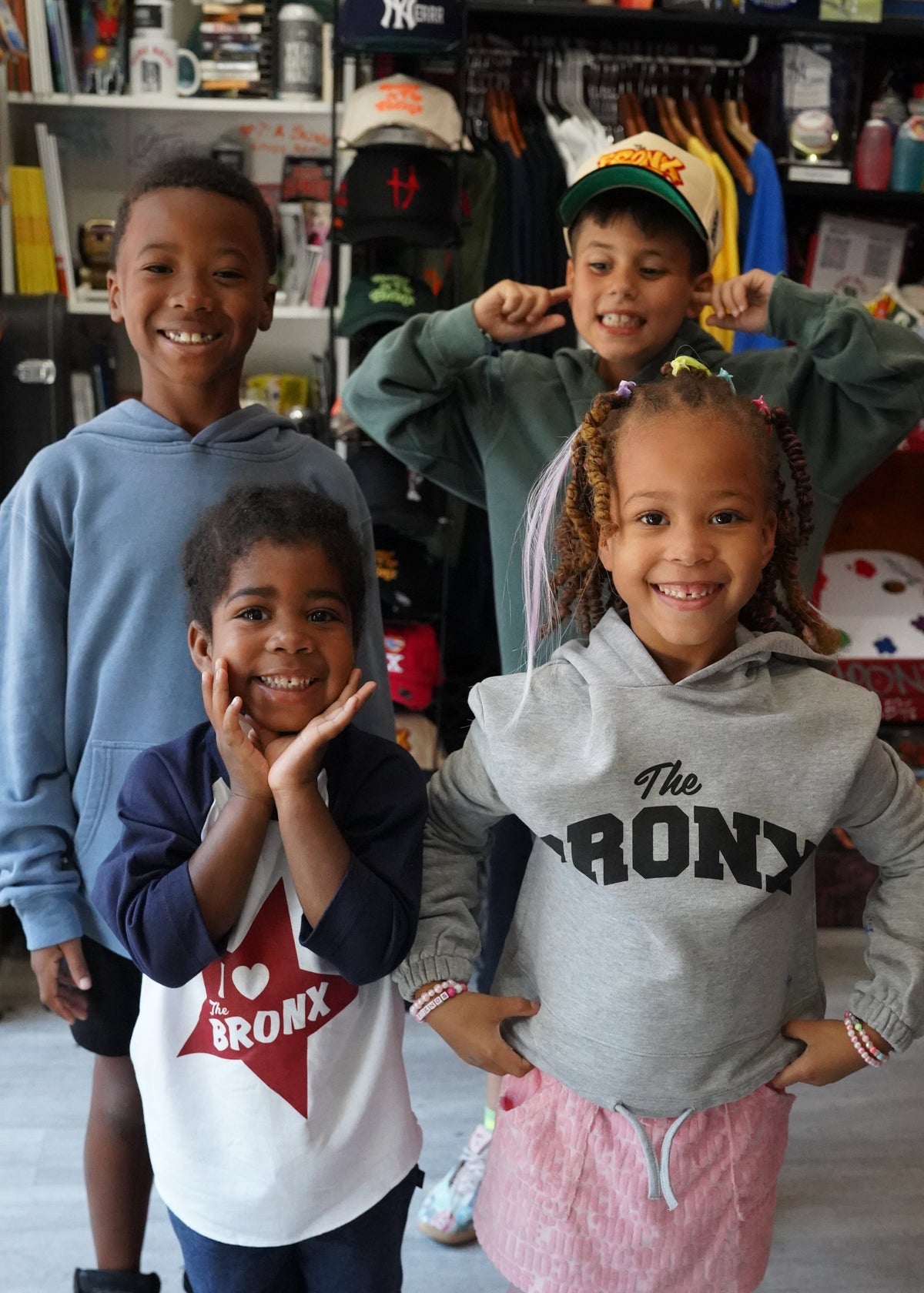 Kid in the Bronx of different ages having fun and gooding off at a store in new fresh merch 