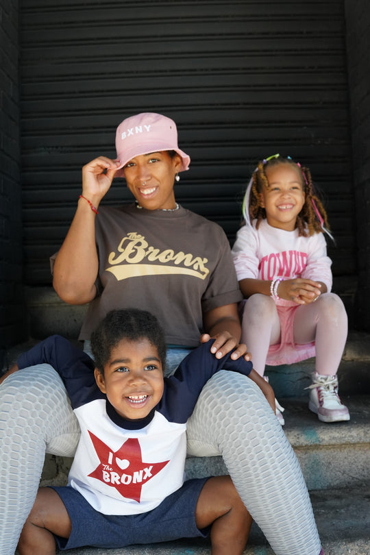 Three children posing together on a vehicle's cargo area.