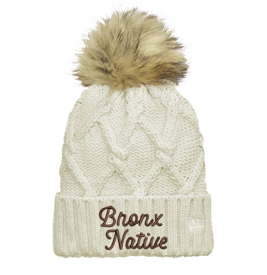 White knit beanie with fur pom-pom and 'Bronx Native' text on a white background