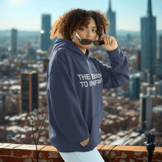 Person wearing a hoodie with 'The Bronx to Infinity' text, standing against a city skyline.