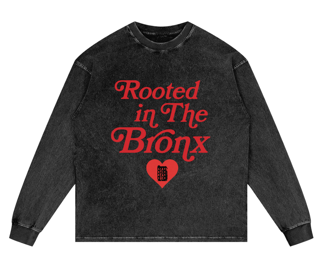 Black long-sleeve shirt with red text 'Rooted in The Bronx' on a white background